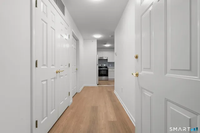 a view of a hallway with wooden floor and staircase