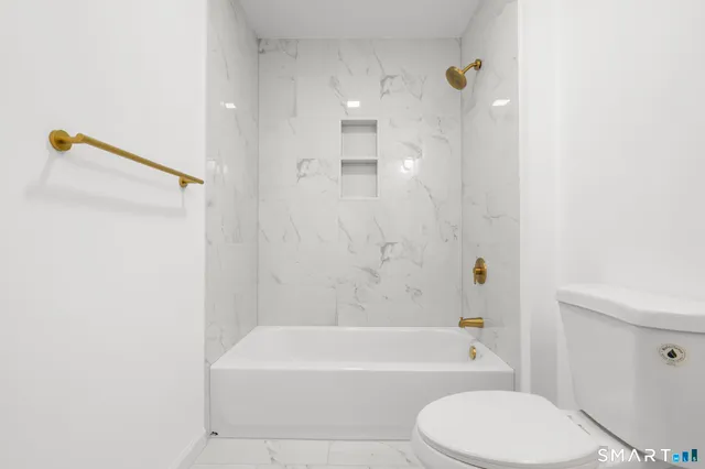 a bathroom with a toilet and a bath tub