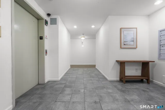 a view of a hallway with closet and a fireplace
