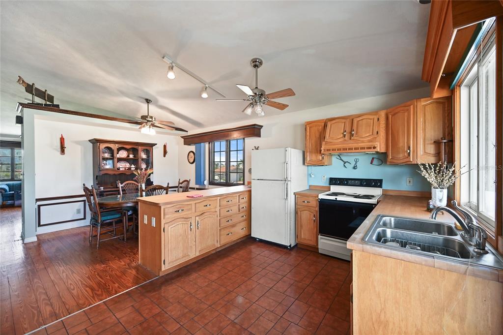 103 Tahiti Circle Naples, FL 34113 - Photo 13 of 37 a kitchen with granite countertop a stove top oven a sink dishwasher and white cabinets with wooden floor