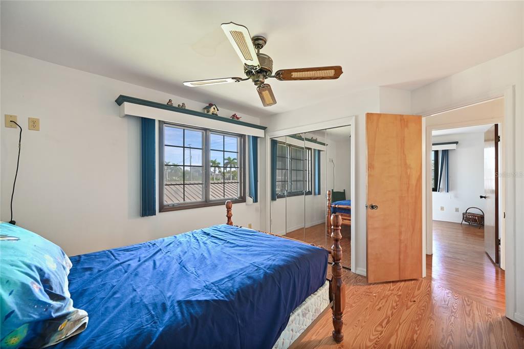 103 Tahiti Circle Naples, FL 34113 - Photo 19 of 37 a bedroom with a bed and wooden floor