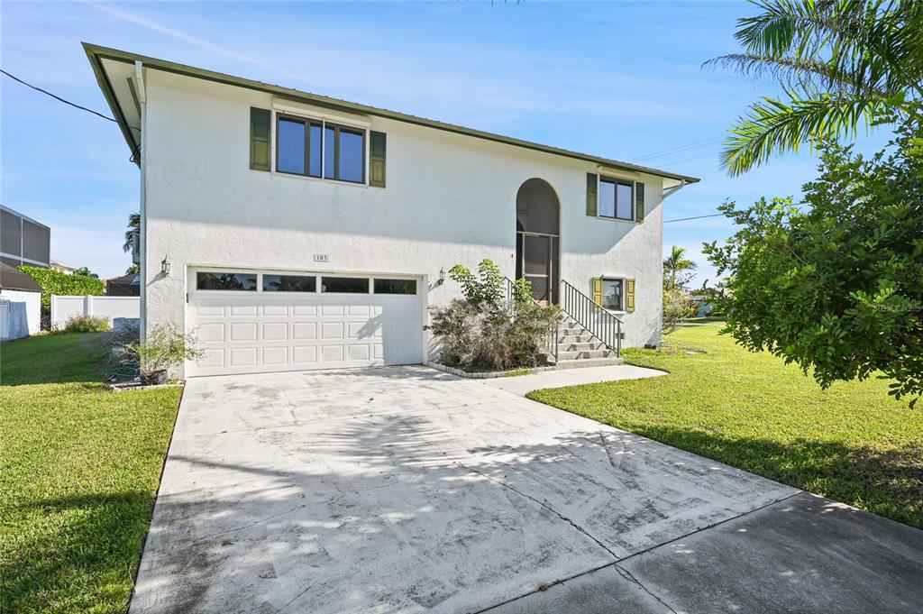 103 Tahiti Circle Naples, FL 34113 - Photo 2 of 37 a front view of a house with a yard and garage