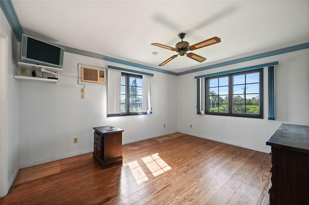 103 Tahiti Circle Naples, FL 34113 - Photo 23 of 37 a view of empty room with wooden floor and fan
