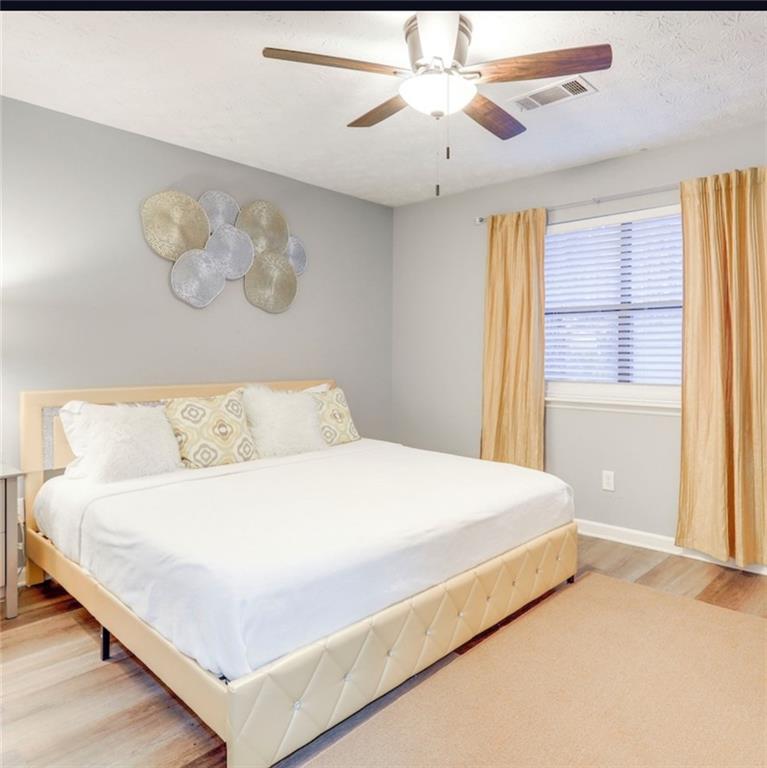 3468 Deer Trace Lithonia, GA 30038 - Photo 9 of 18 a bedroom with a large bed and a chandelier