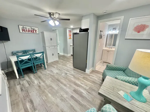 a living room with furniture and a refrigerator