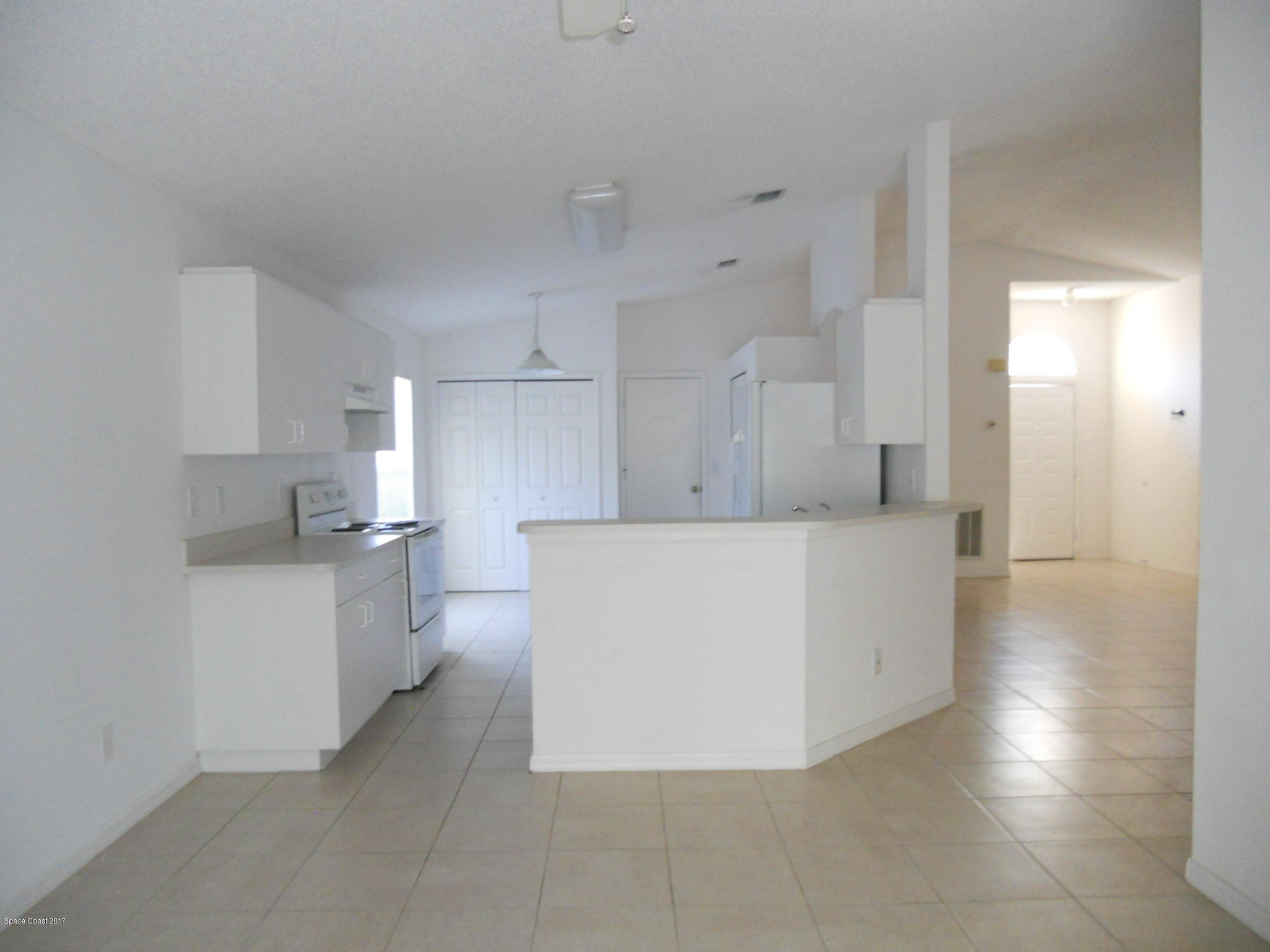 540 Benton Drive Melbourne, FL 32901 - Photo 5 of 14 a large white kitchen with cabinets and a refrigerator
