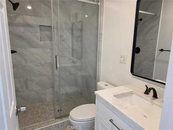 a bathroom with a sink a toilet and shower