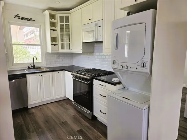 a kitchen with granite countertop white cabinets and white appliances