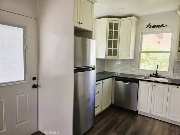 a kitchen with stainless steel appliances granite countertop a sink and a window