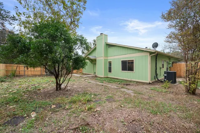 a view of a house with a yard and large tree