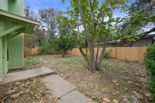 a backyard of a house with lots of plants and trees