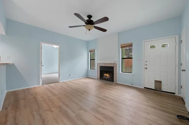 a view of empty room with wooden floor and fireplace