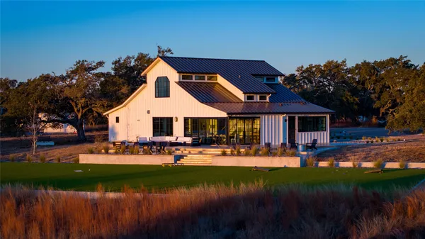 a front view of a house with sitting area and swimming pool