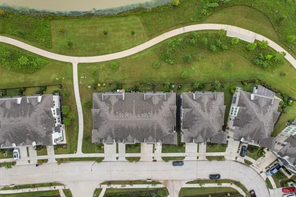 an aerial view of residential houses with outdoor space and swimming pool