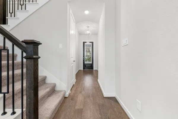 a view of a hallway with wooden floor and staircase