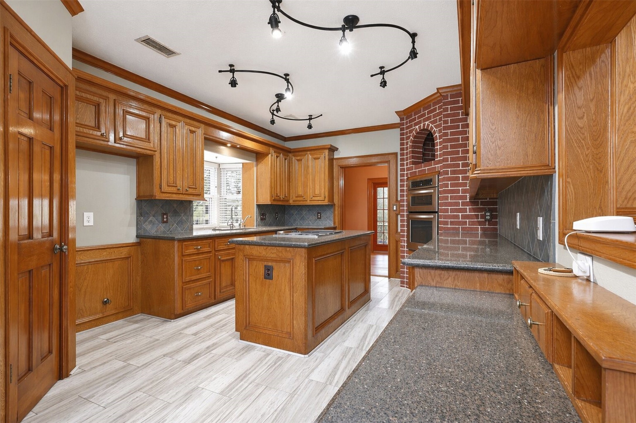 6118 Hampton Way Court Spring, TX 77389 - Photo 4 of 27 Kitchen offers a Jenn Air Cook Top in the island. Pantry to the left. Built in desk to the right. Kitchen Aid Dishwasher to the right of the sink.