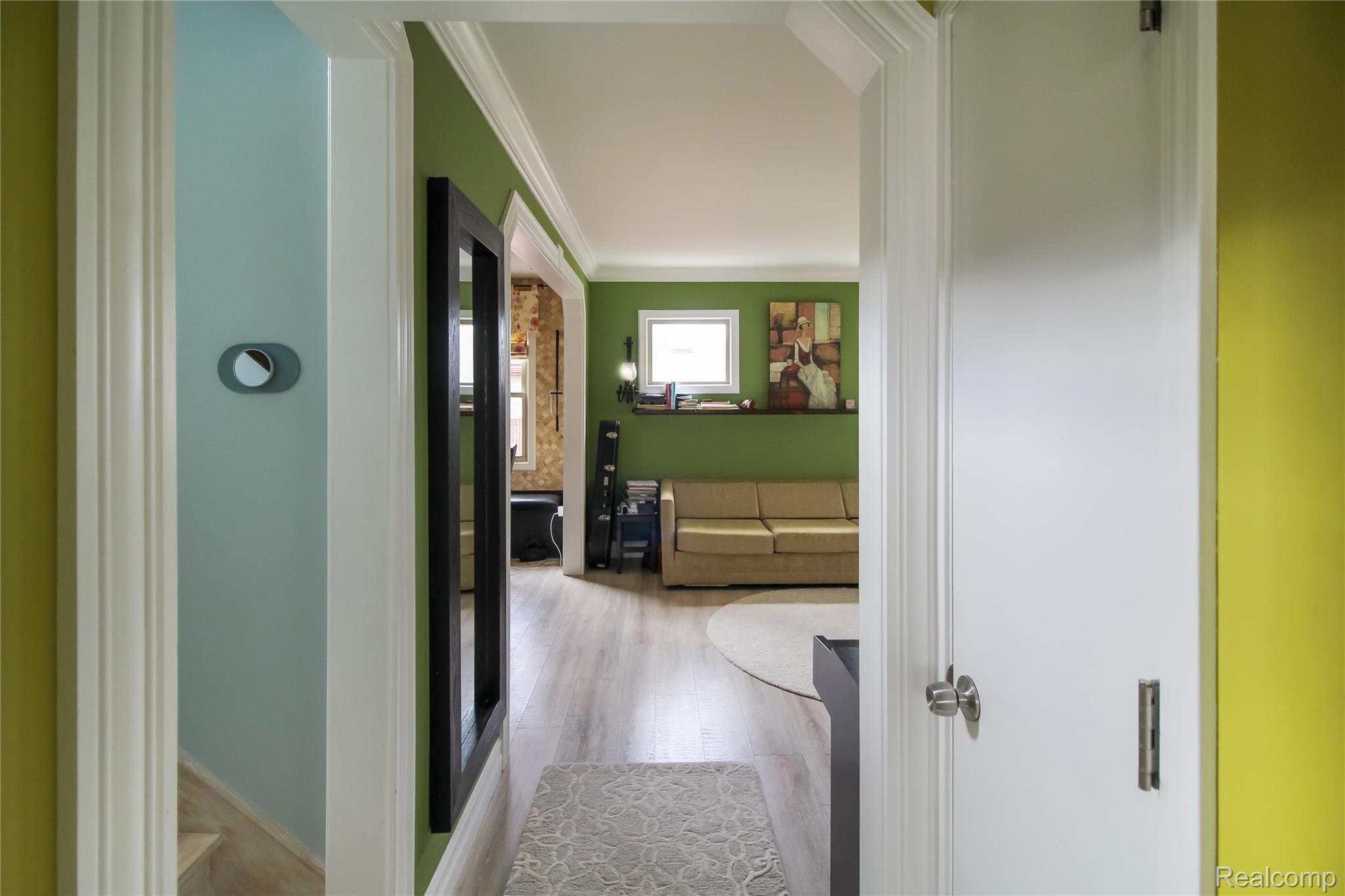 5953 Cooper Street Taylor, MI 48180 - Photo 11 of 33 Hallway with wood-finish flooring, white crown molding, and lime green walls