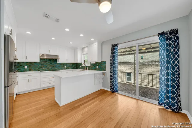 a view of a kitchen with wooden floor and a window