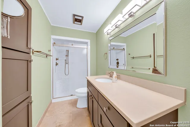 a bathroom with a sink a toilet and shower