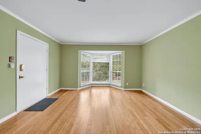 a view of a room with wooden floor and windows