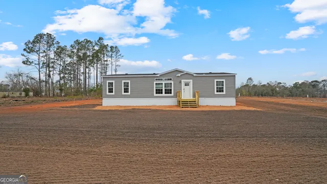 a front view of a house with a yard and lake view