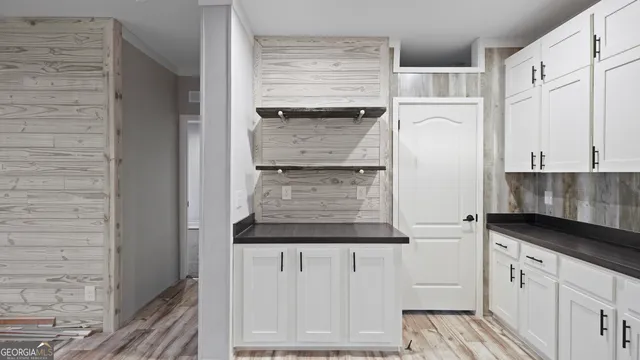 a kitchen with granite countertop white cabinets and white appliances