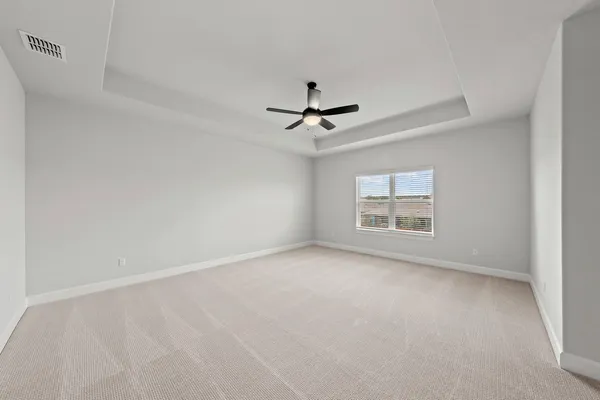 an empty room with a ceiling fan and windows