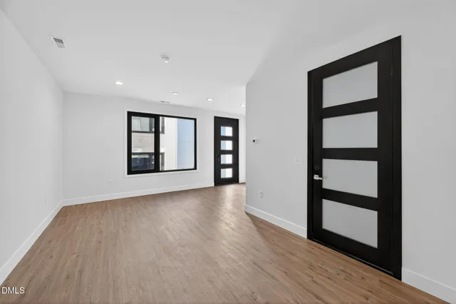 a kitchen with stainless steel appliances granite countertop white cabinets and wooden floor