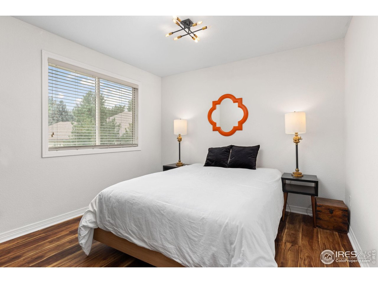 7271 Irwin Court Fort Collins, CO 80528 - Photo 30 of 49 a bedroom with a bed and wooden floor