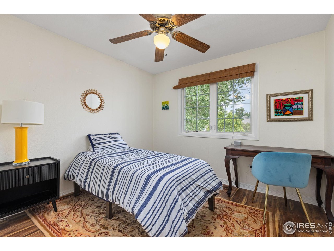 7271 Irwin Court Fort Collins, CO 80528 - Photo 31 of 49 a bedroom with a bed a table and a chandelier