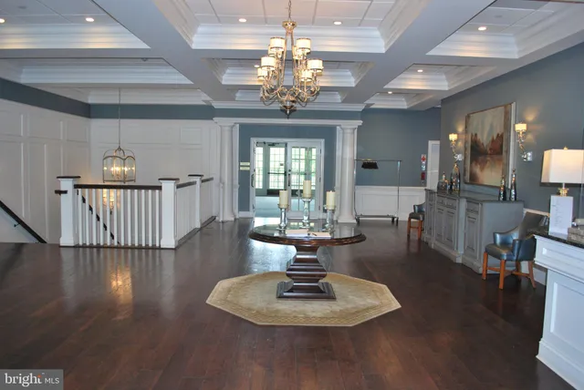 a dining room with wooden floor a chandelier a wooden table and chairs