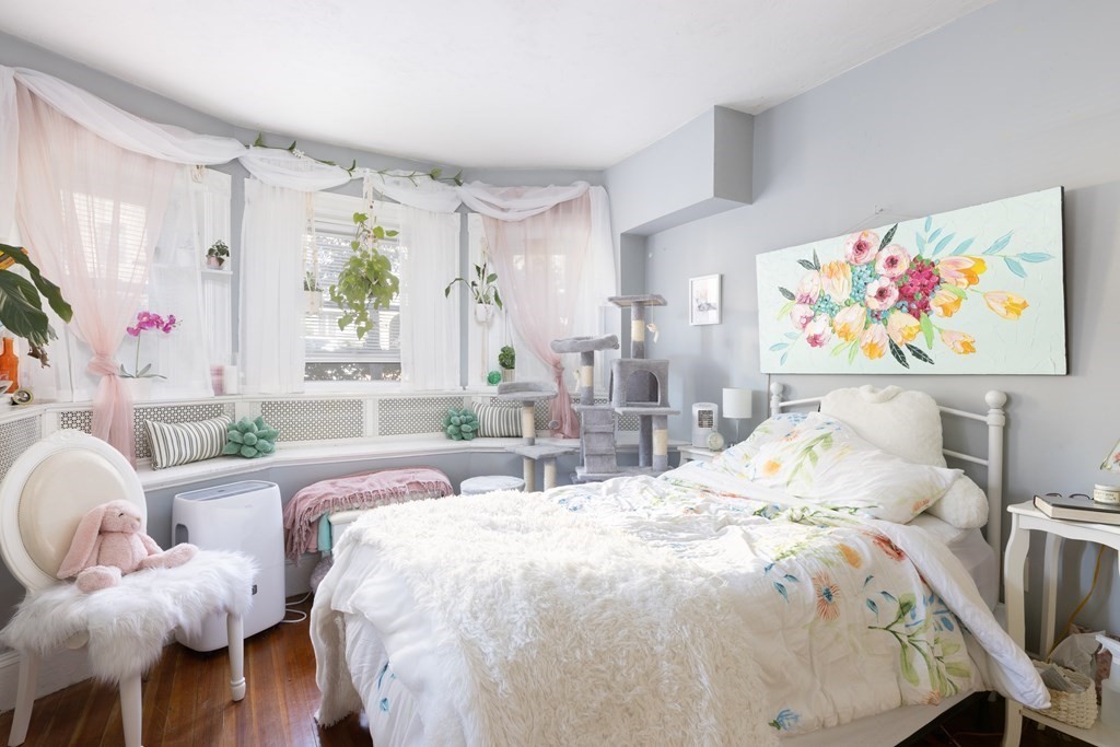 16 Garrison Road, Unit 7 Brookline, MA 02445 - Photo 4 of 9 a bedroom with a bed and glass windows