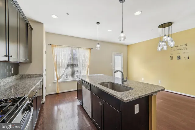 a kitchen with granite countertop a stove and a wooden floors