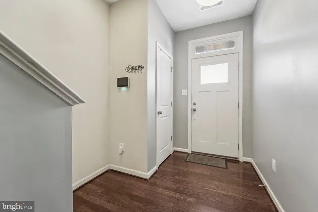 a view of an empty room with wooden floor and closet