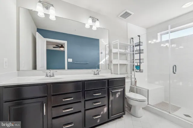 a bathroom with a double vanity sink toilet and shower
