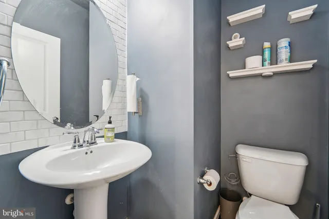 a bathroom with a toilet sink and mirror