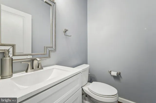 a bathroom with a sink toilet and mirror