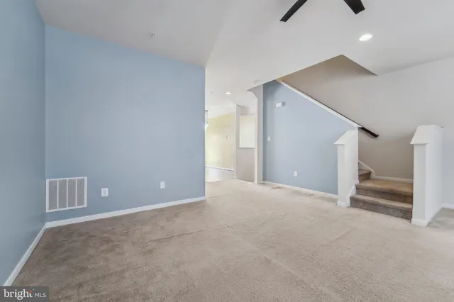 a view of an empty room with closet and windows