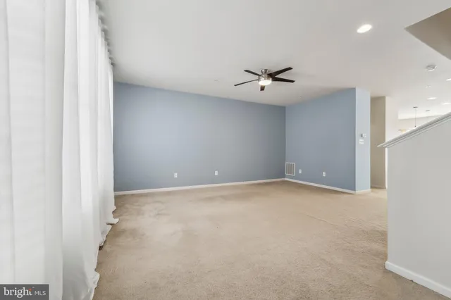 an empty room with a ceiling fan and a window