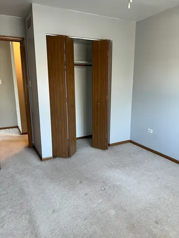 an empty room with closet and mirror