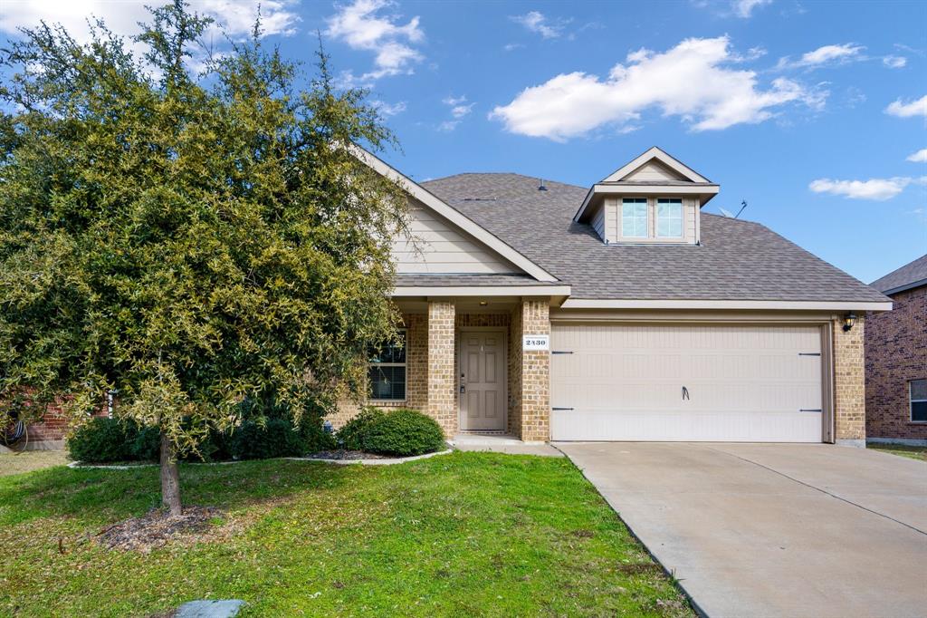 View of front of house with a front yard and a garage
