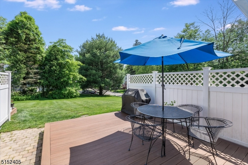429 Green Village Road, Unit 2 Green Village, NJ 07935 - Photo 25 of 26 a view of a table and chairs under an umbrella in backyard