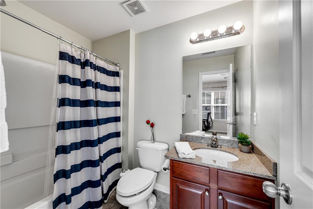 3039 Liberty Way Northwest Atlanta, GA 30318 - Photo 31 of 43 a bathroom with a sink a toilet a shower and a mirror