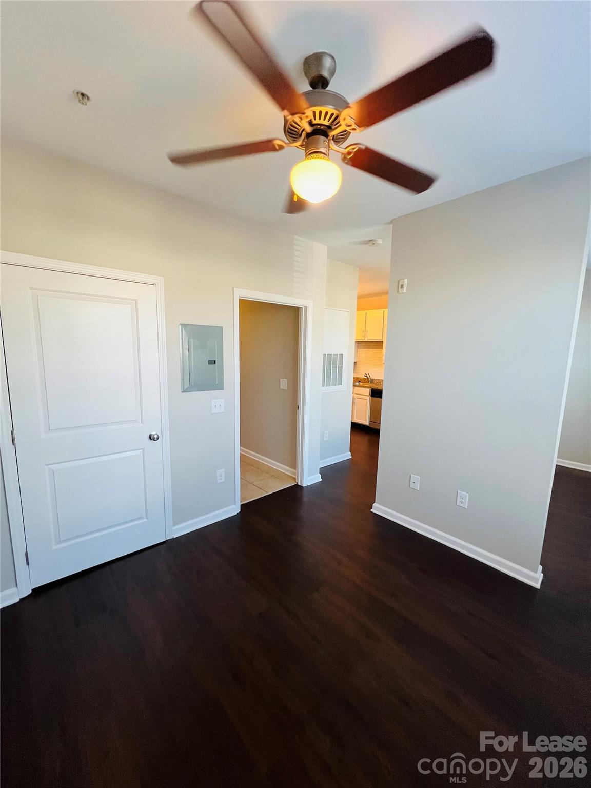 4310 Park Road, Unit 207 Charlotte, NC 28209 - Photo 6 of 9 a view of an empty room with wooden floor and a ceiling fan