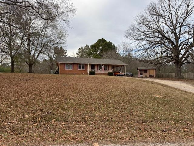 Single story home featuring a porch and a carport
