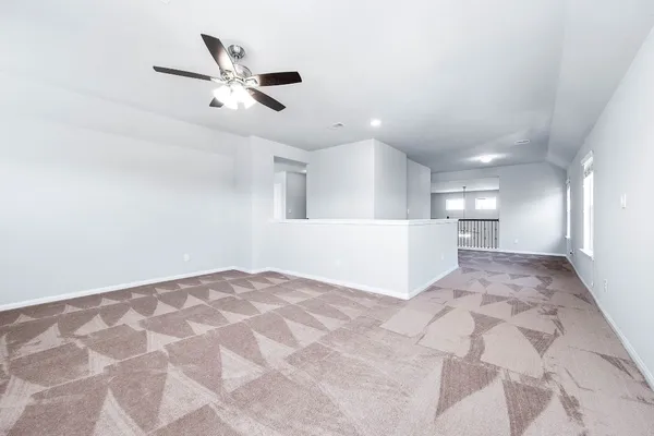 a view of an empty room and kitchen view