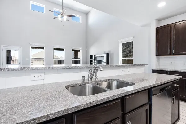 a kitchen with granite countertop a sink and a stove