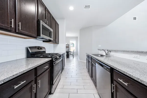 a kitchen with stainless steel appliances granite countertop a sink a stove oven and cabinets