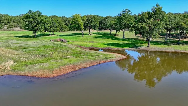 a swimming pool with wooden fence and trees in the background