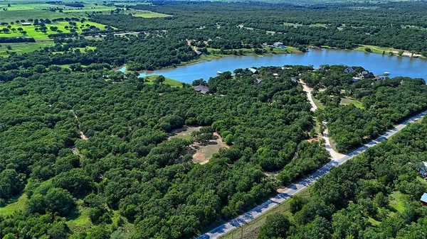 an aerial view of residential houses with outdoor space and trees